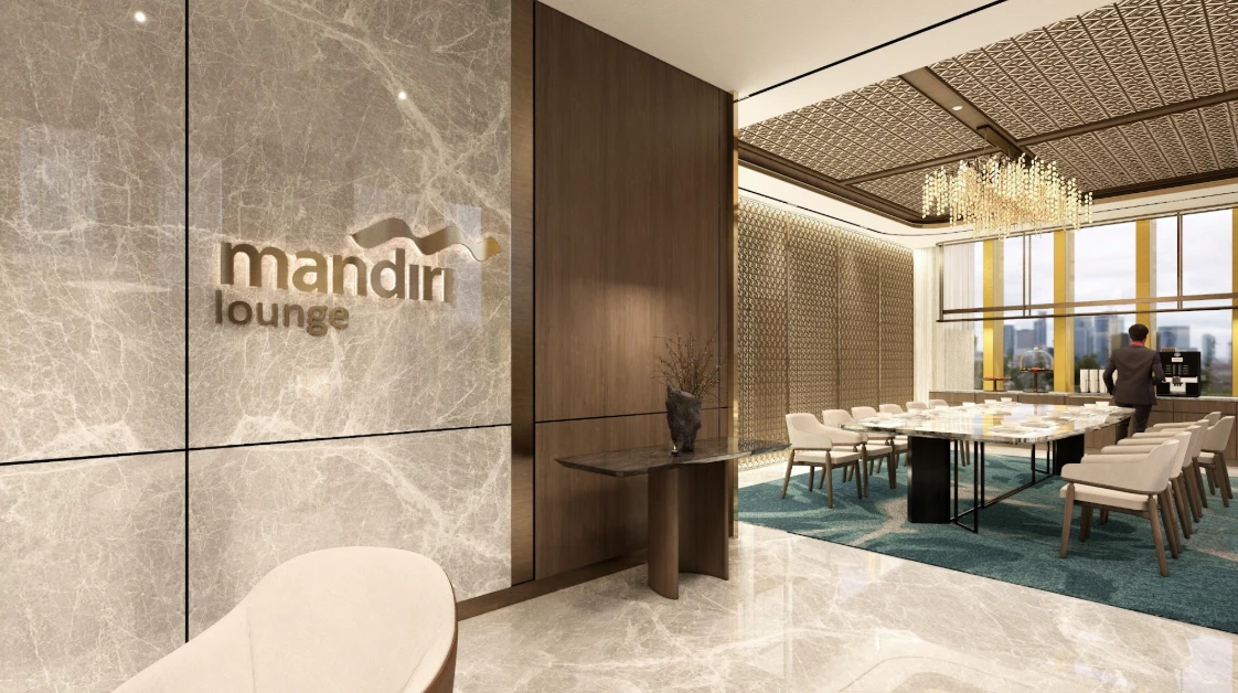 Sudut entrance menuju Dining Lounge — meja konsol, logo Mandiri Lounge, dan chandelier kristal di kejauhan